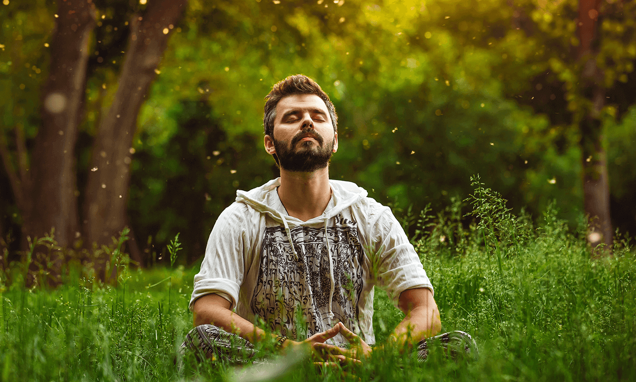 a man meditating in a field