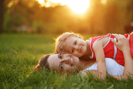 mother and daughter laying in the grass