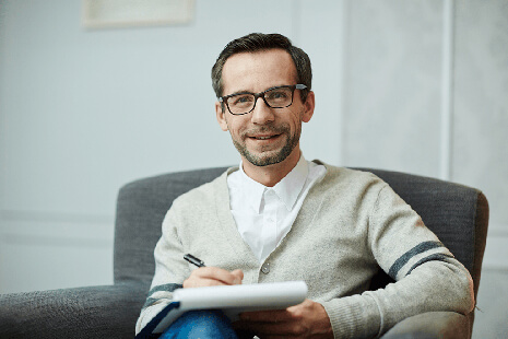 a therapist smiling at you from his chair