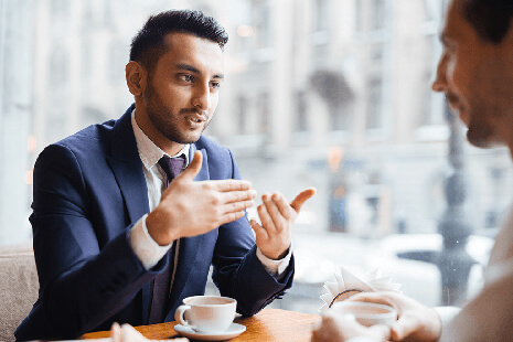 two men discussing business over coffee