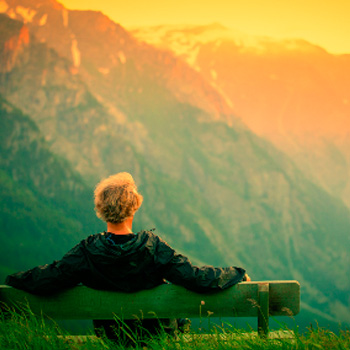 person sitting on bench on mountain