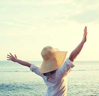 Woman at the beach with her arms in the air