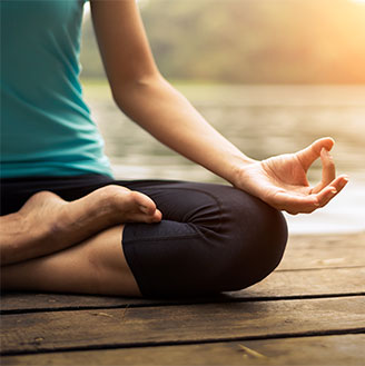 Close-up photo of someone meditating in the lotus position